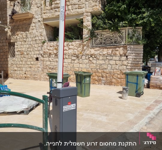 שער חשמלי עם מחסום לבן ואפור בחניה